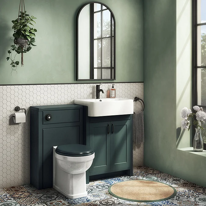 a green bathroom with dark green sink vanity unit and sage green walls