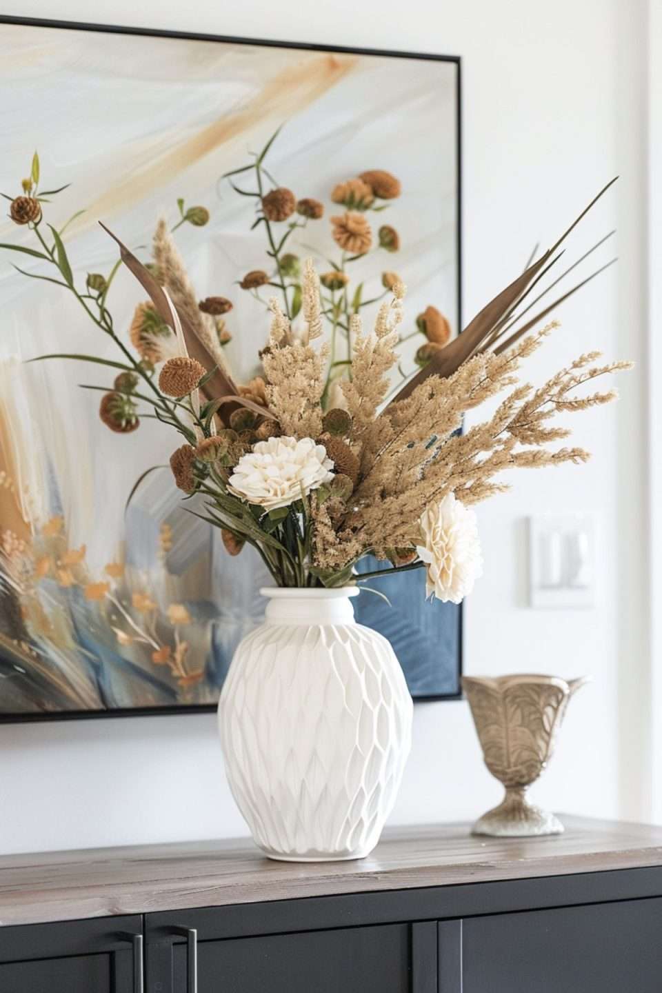 a vase of dried flowers and pampas grass